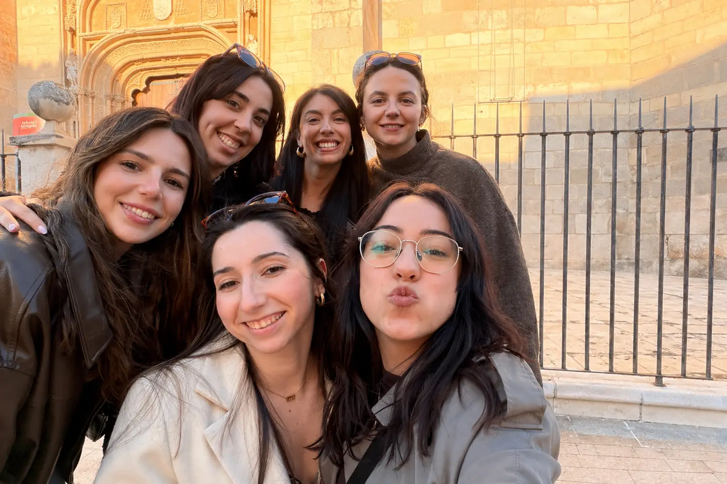 El equipo de psicólogas sonriendo juntas frente a un edificio histórico de Alcalá de Henares
